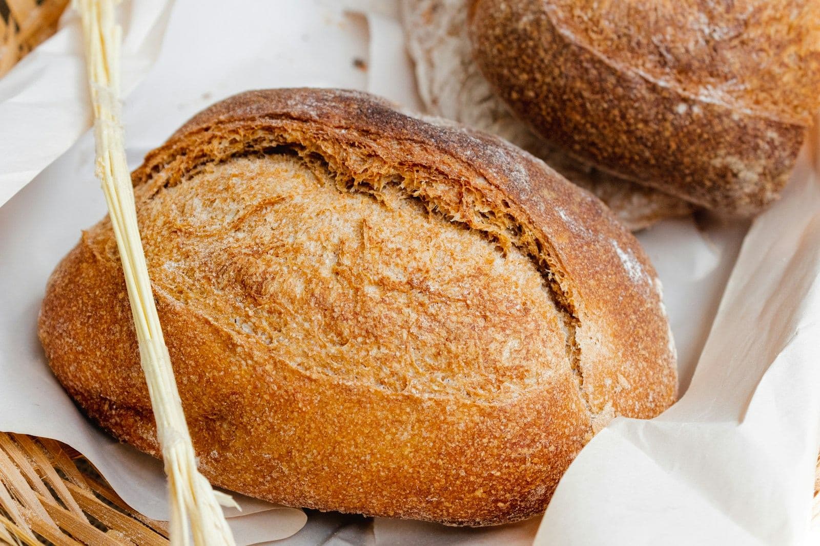 Crusty loaves of bread in a basket lined with paper